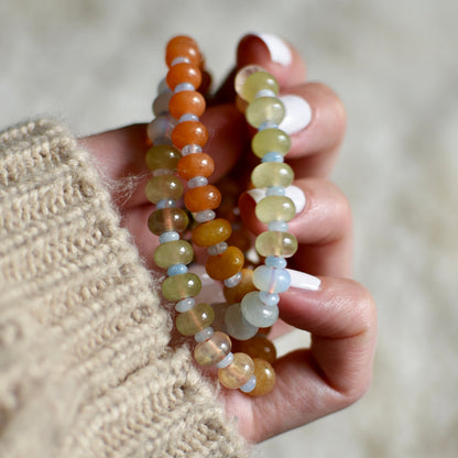 Hand holding two beaded necklace