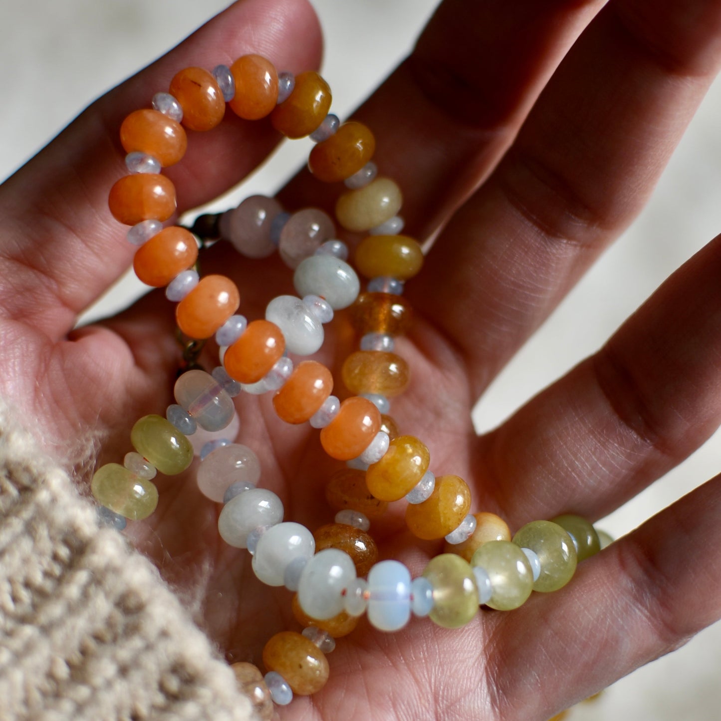 Hand holding two beaded necklace