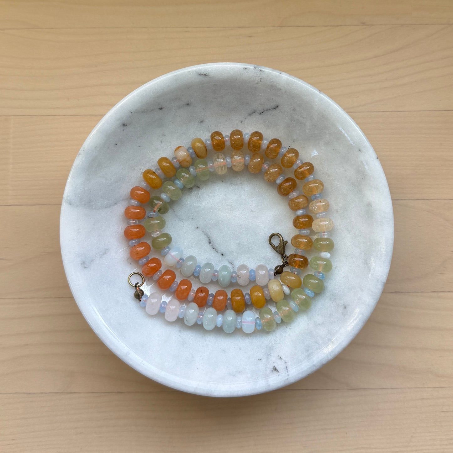 Beaded bracelet on a marble dish with a wooden background