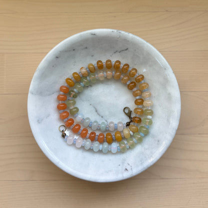 Beaded bracelet on a marble dish with a wooden background