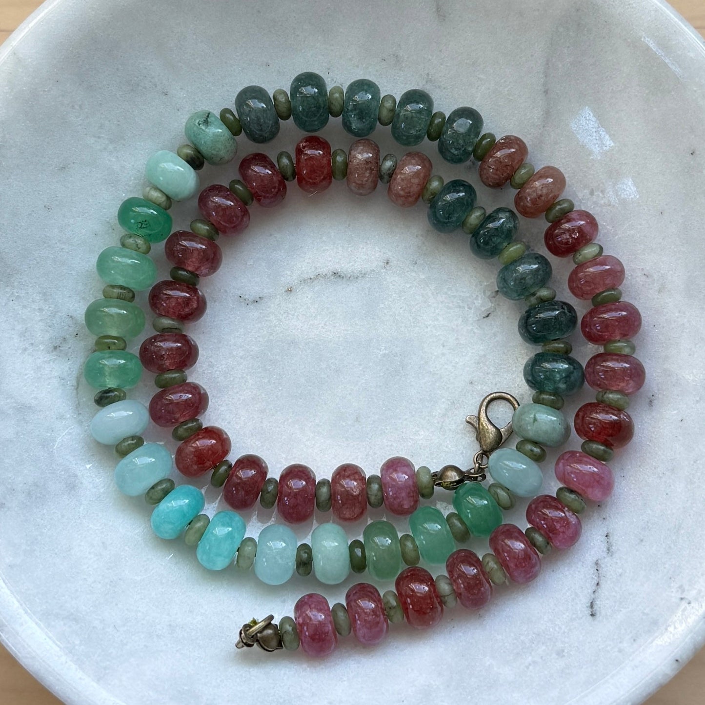 Beaded bracelet on a marble dish with a wooden background